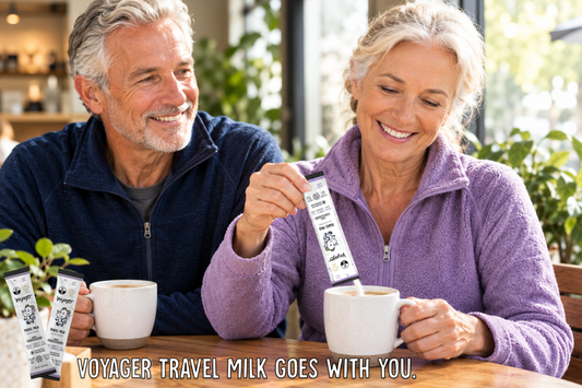 Active older couple on a hiking trail with a water bottle and a Voyager Goat Milk sachet